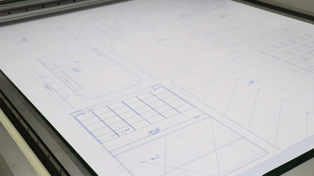 Automated paper pattern plotter cutter at TacticalCN factory ensuring precise replication of brand designs.